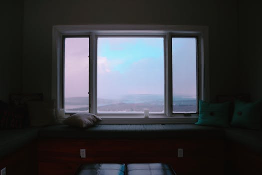 Tranquil view from a window seat with a calming outdoor vista, featuring soft cushions and a peaceful atmosphere.