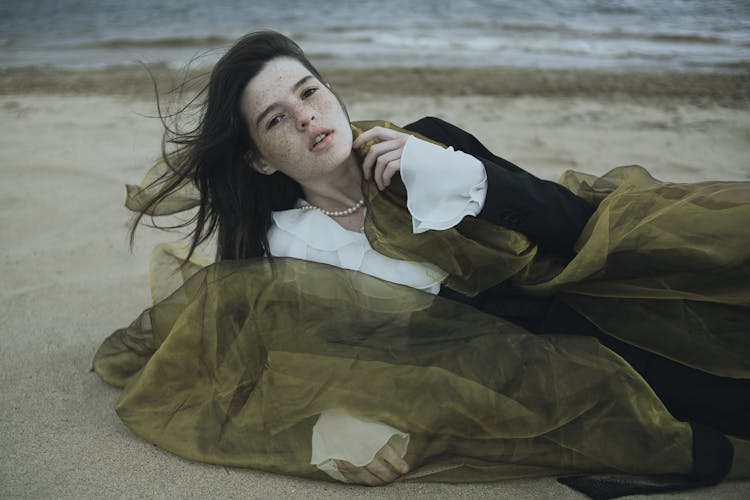 Brunette Woman In White Shirt Lying On Beach