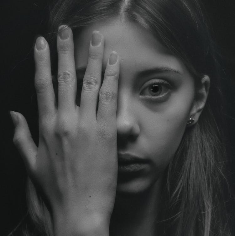 Grayscale Photo Of Woman Covering Her Face By Her Hand