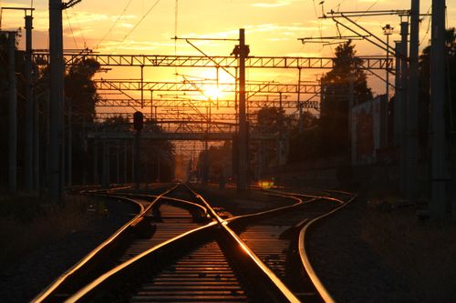 Free A stunning view of railway tracks at sunset, capturing warm, golden tones. Stock Photo