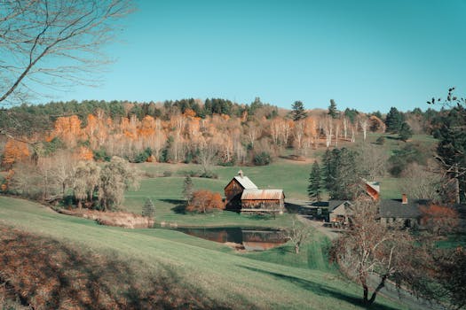 Captivating autumn landscape featuring a classic farmhouse and barn in the rural countryside of Woodstock, Vermont.