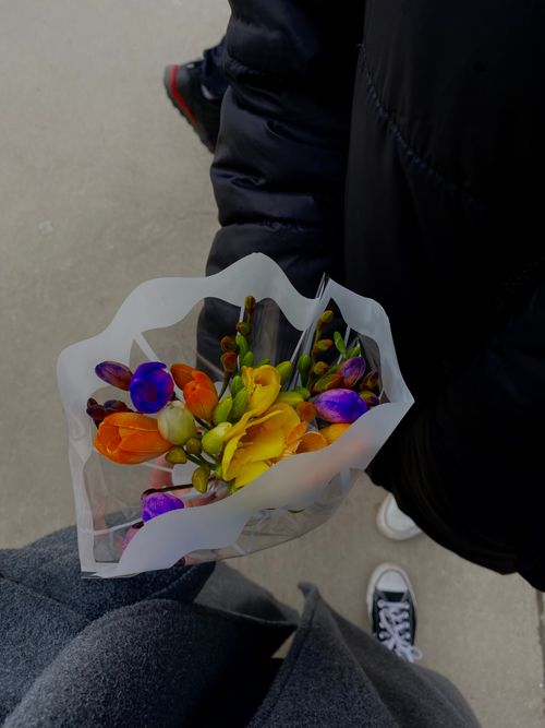 Free Colorful spring bouquet held in casual attire, outdoor setting. Stock Photo