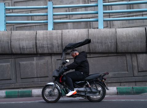 Adult man on a motorcycle riding through the city, showcasing urban transportation.