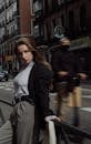 Woman Leaning against Railing and Man Riding Segway in Town Street