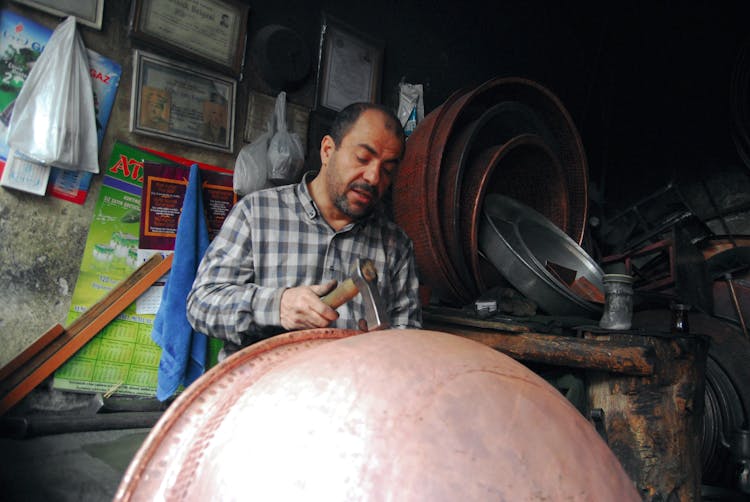 Man Holding Hammer Working On Shaping Basin