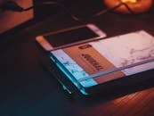 温暖的灯光下，平静的工作空间里摆放着日记、智能手机和笔