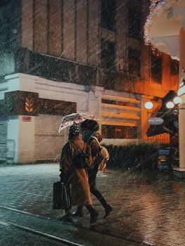 Two people walking under an umbrella on a rainy night in Istanbul, Turkey.