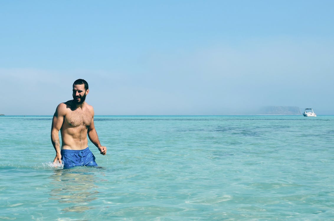 Man in Blue Swimming Trunks on the Beach · Free Stock Photo