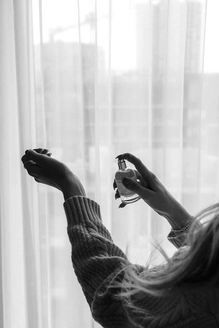 Grayscale Photography Of Woman Spraying Perfume