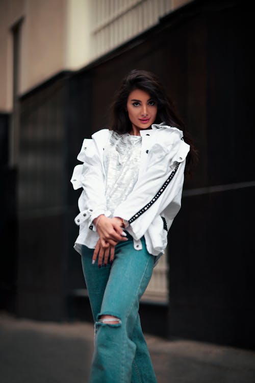 Free Pretty Woman in White Jacket and Blue Ripped Jeans Stock Photo