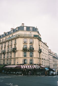 Parisian building with corner cafe in urban setting, capturing classic architecture and charm.