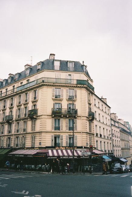 Parisian building with corner cafe in urban setting, capturing classic architecture and charm.