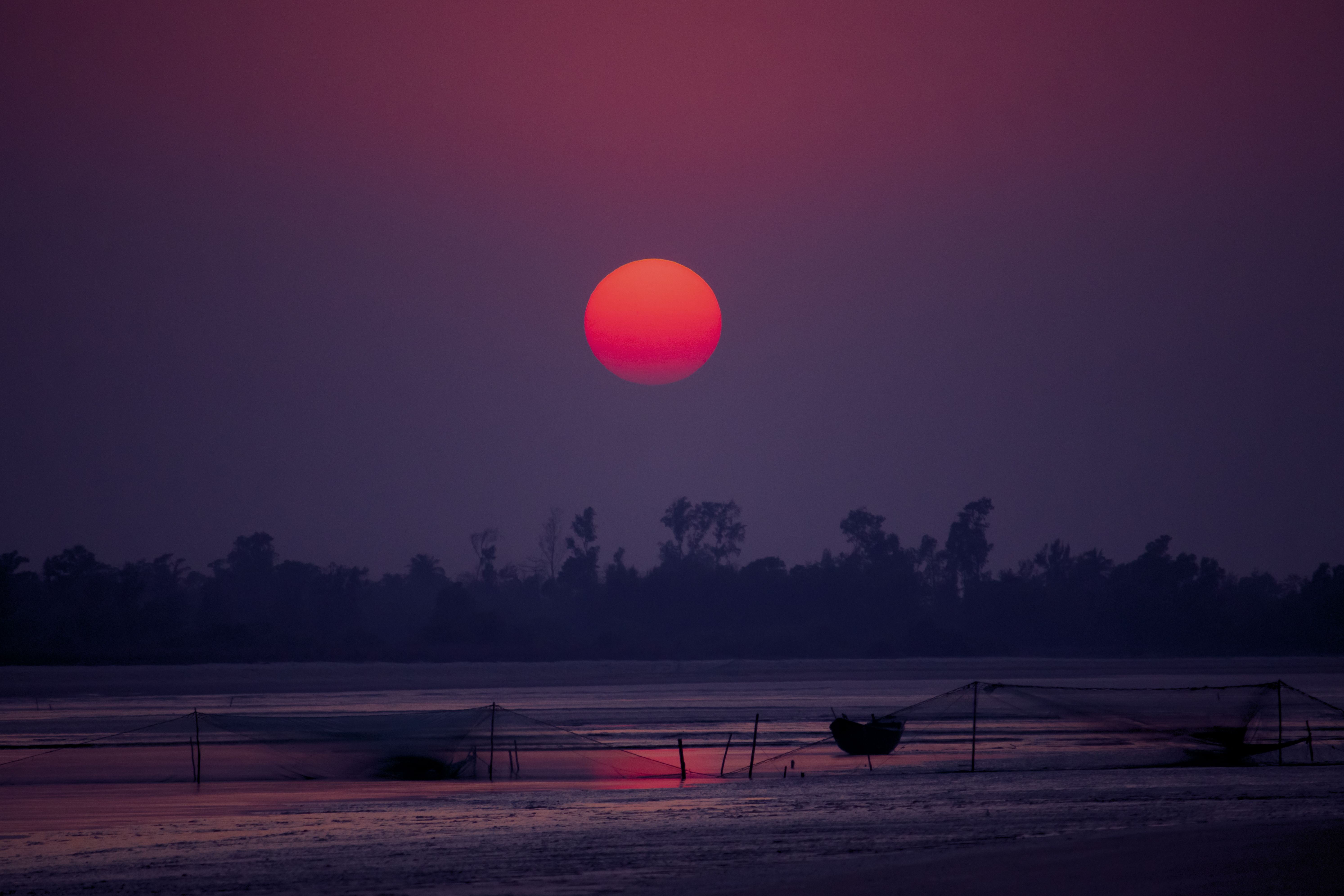 Chinese fishing nets silhouetted against sunset on the Fort Kochi waterfront
