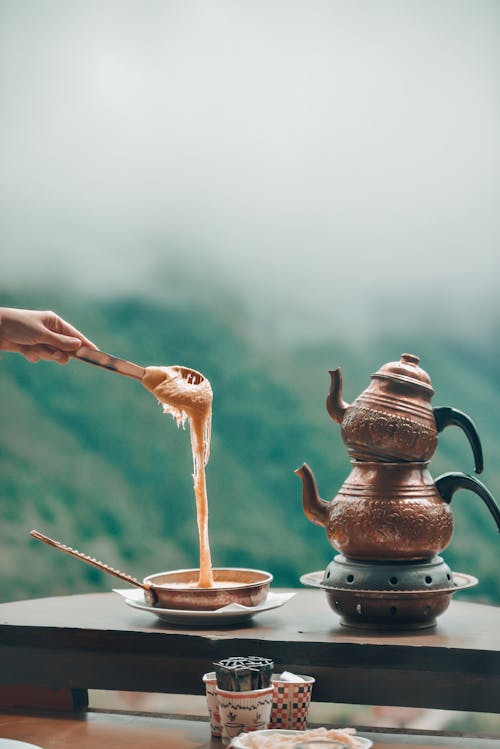 Free Person Pouring Coffee on Brown Ceramic Teapot Stock Photo
