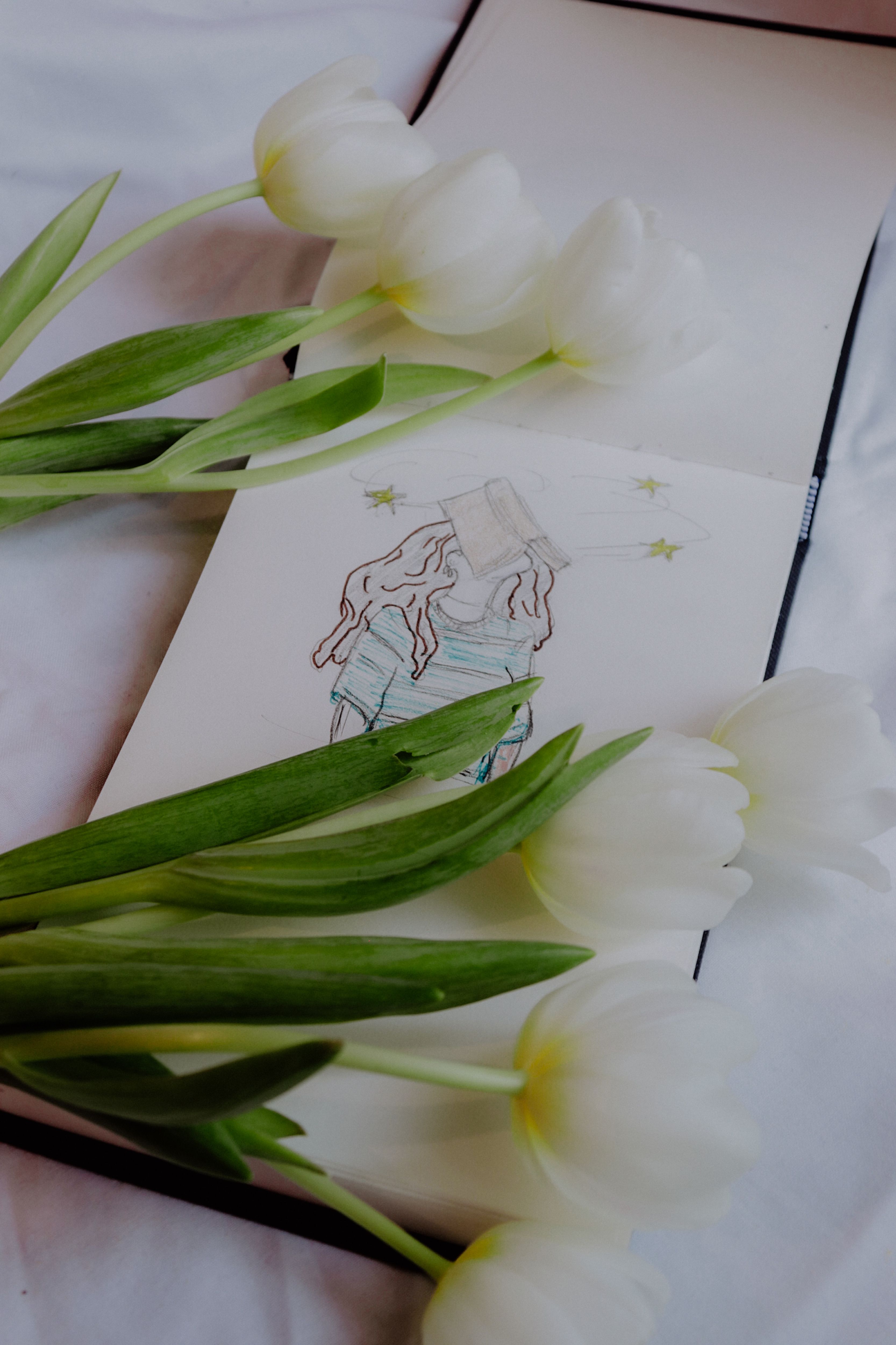 Delicate sketch surrounded by white tulips in a Parisian ambiance, exuding a serene and artistic vibe.