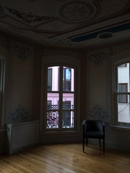 Stylish room with decorative windows, wooden floors, and an elegant armchair.