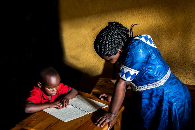 A Teacher Teaching A Blind Student