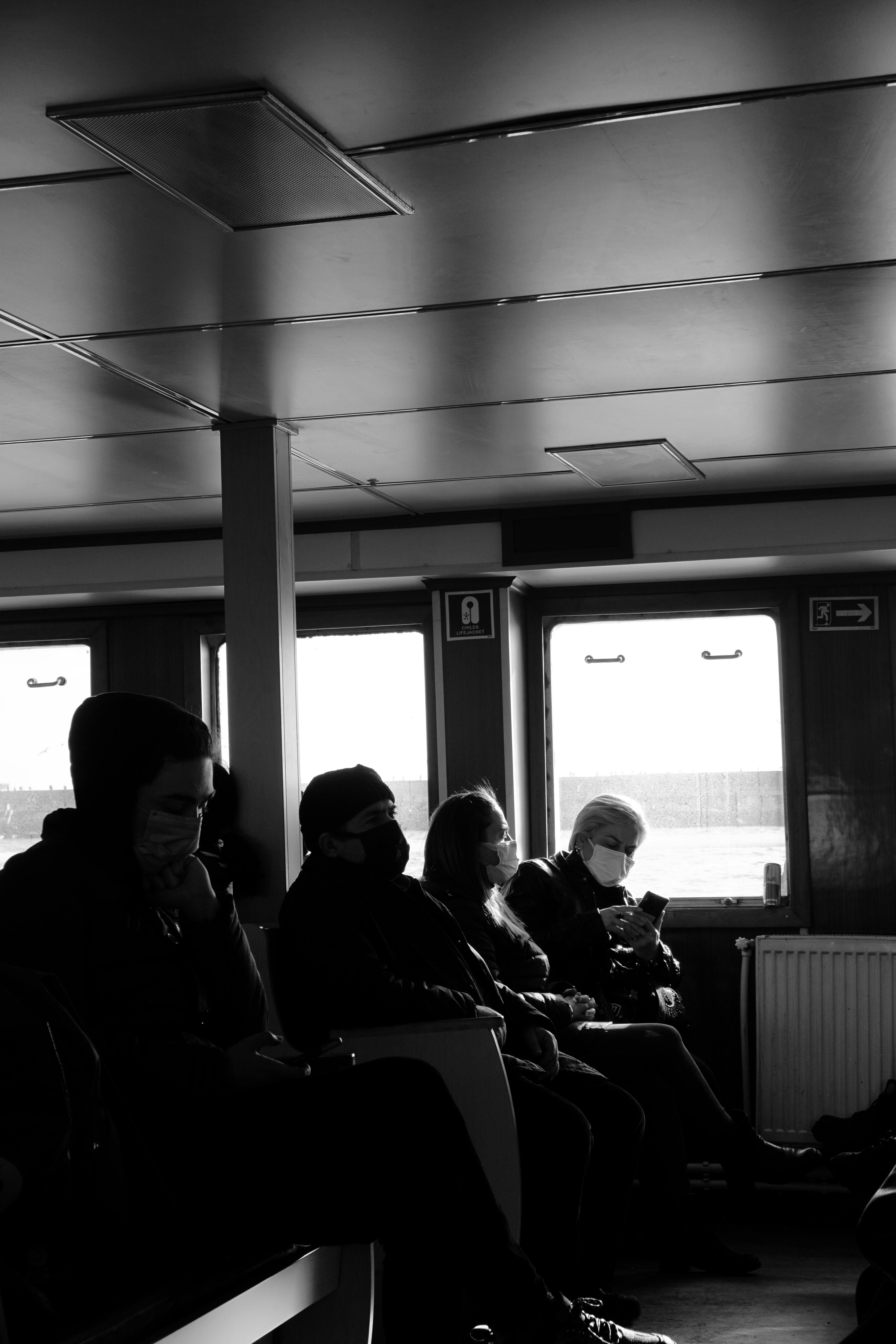 Free Black and white photo of commuters sitting on a ferry in Istanbul, highlighting public transportation. Stock Photo