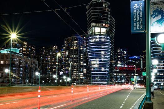 Vancouver's illuminated skyline and vibrant traffic trails at night. Capturing urban life.