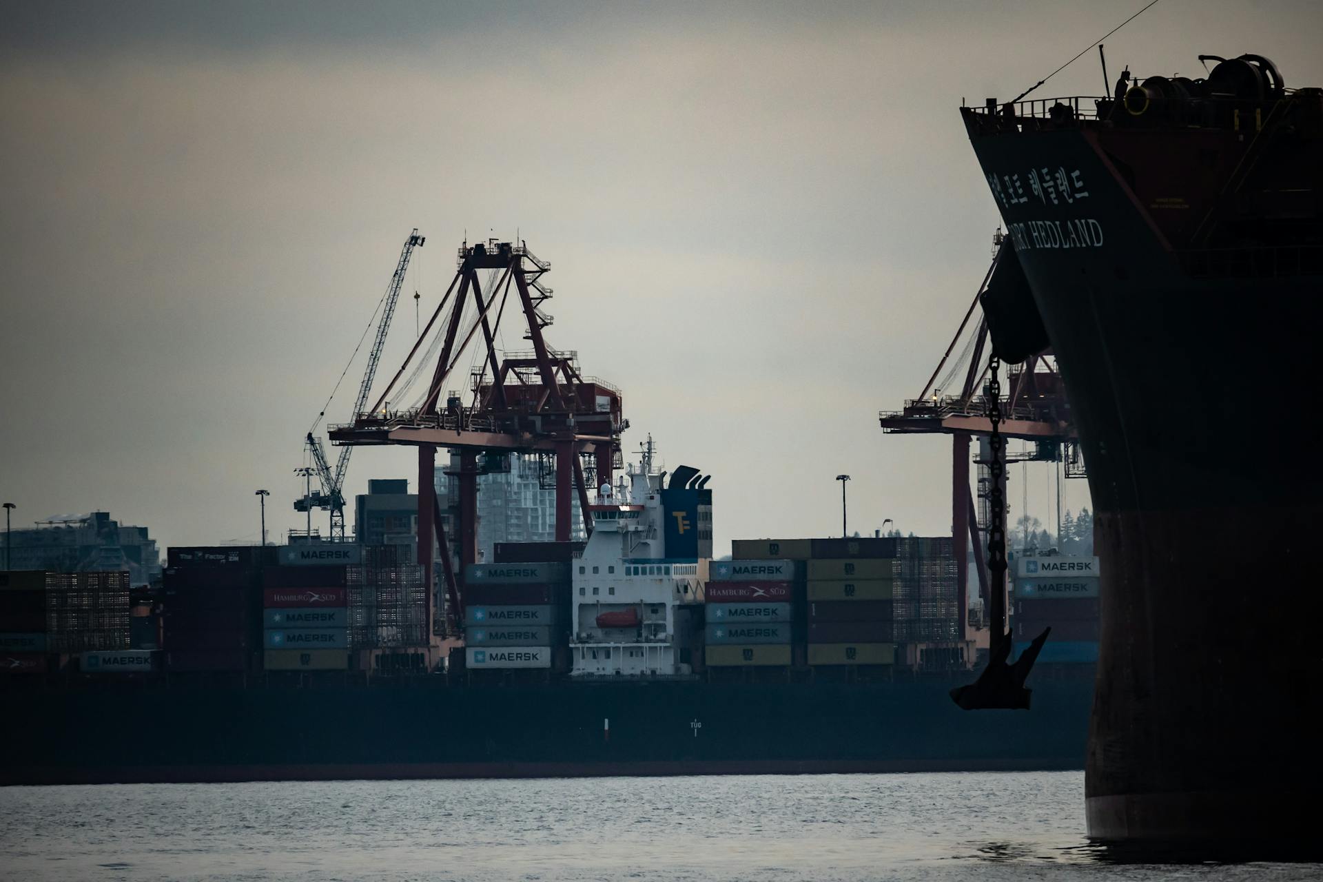 Cranes loading cargo containers onto ships at Vancouver's bustling port.
