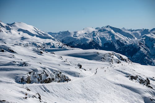 People Walking on Snow Covered Mountain