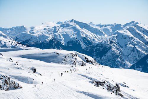 People Walking on Snow Covered Mountains