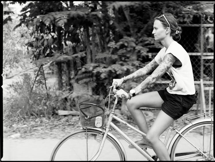 Black And White Photo Of Woman Riding A Bicycle