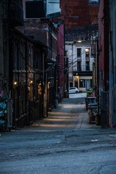 Moody shot of a deserted urban alleyway in Vancouver during dusk, capturing gritty architecture.