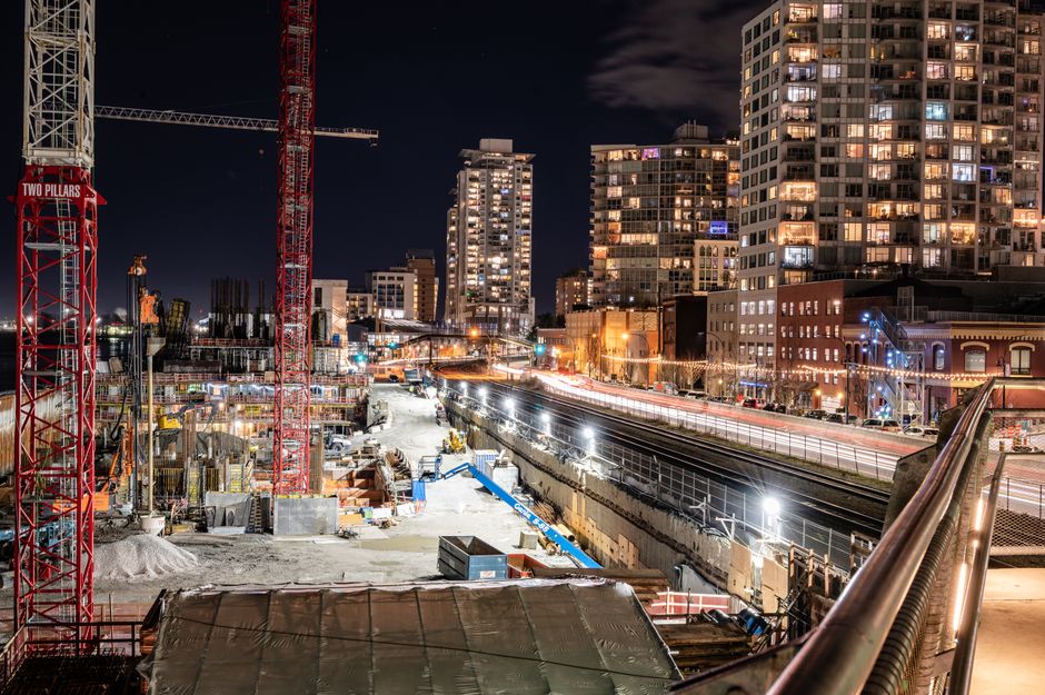 A vibrant nighttime view of construction and city lights in New Westminster, BC.