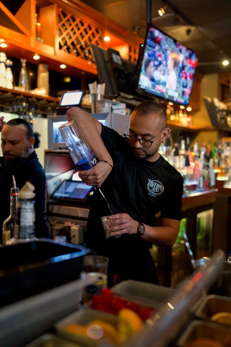 A Bartender Pouring A Drink