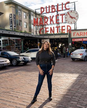 Smiling woman in urban street at famous market, enjoying sunny day outdoors.