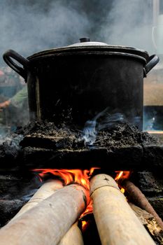 Black pot cooking over bamboo fire stove in Slawi, Central Java.