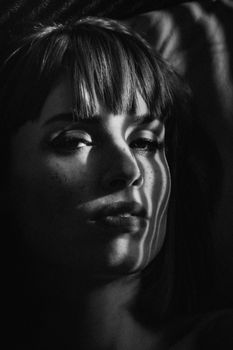 An artistic monochrome portrait of a woman with dramatic lighting and shadows.. artistic, monochrome, portrait