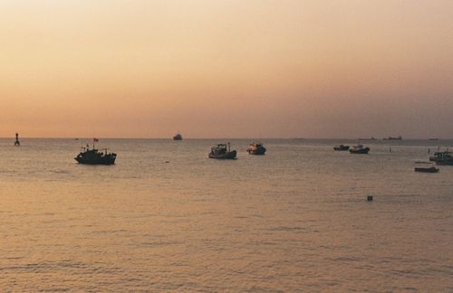Free Peaceful scene of boats on the ocean at twilight under a soft sky. Stock Photo