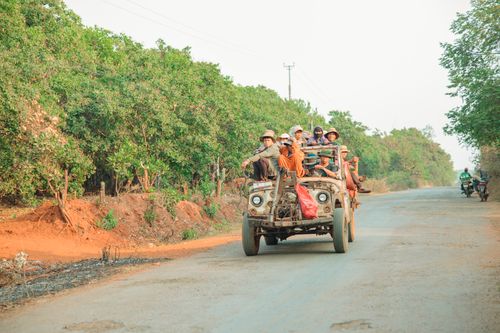 Free A group of people traveling on a vintage vehicle along a rural road in Gia Nghia, Vietnam. Stock Photo