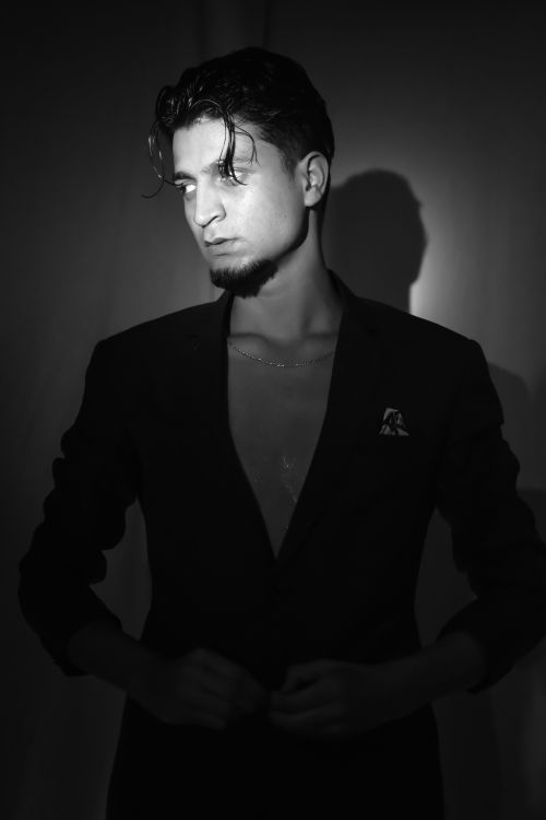 Free Moody black and white portrait of a man in a suit with strong lighting and shadows. Stock Photo