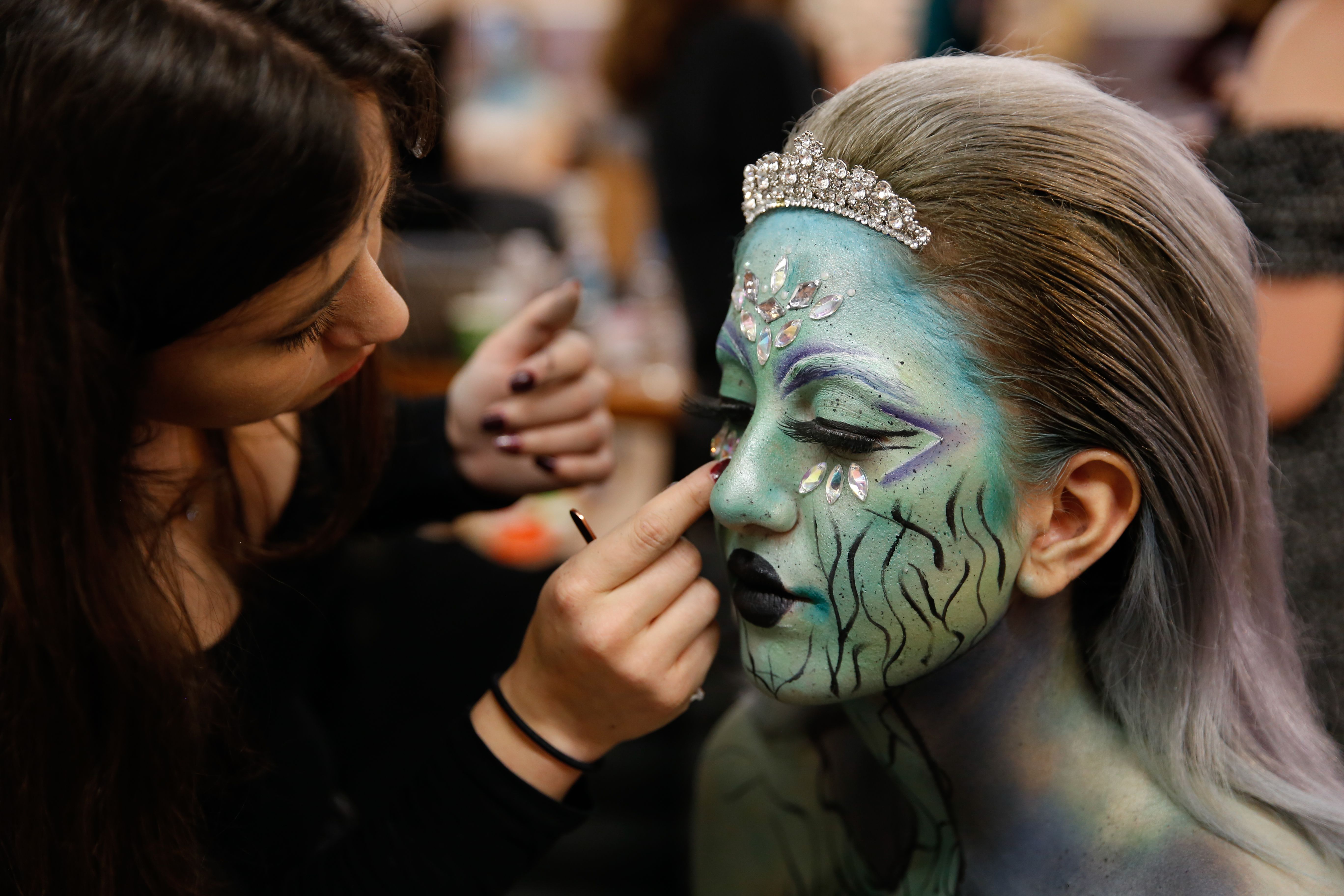 Artistic face painting session in İstanbul with a unique makeup design being applied.