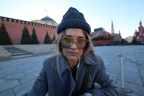 A Woman in Gray Coat Wearing Beanie and Sunglasses