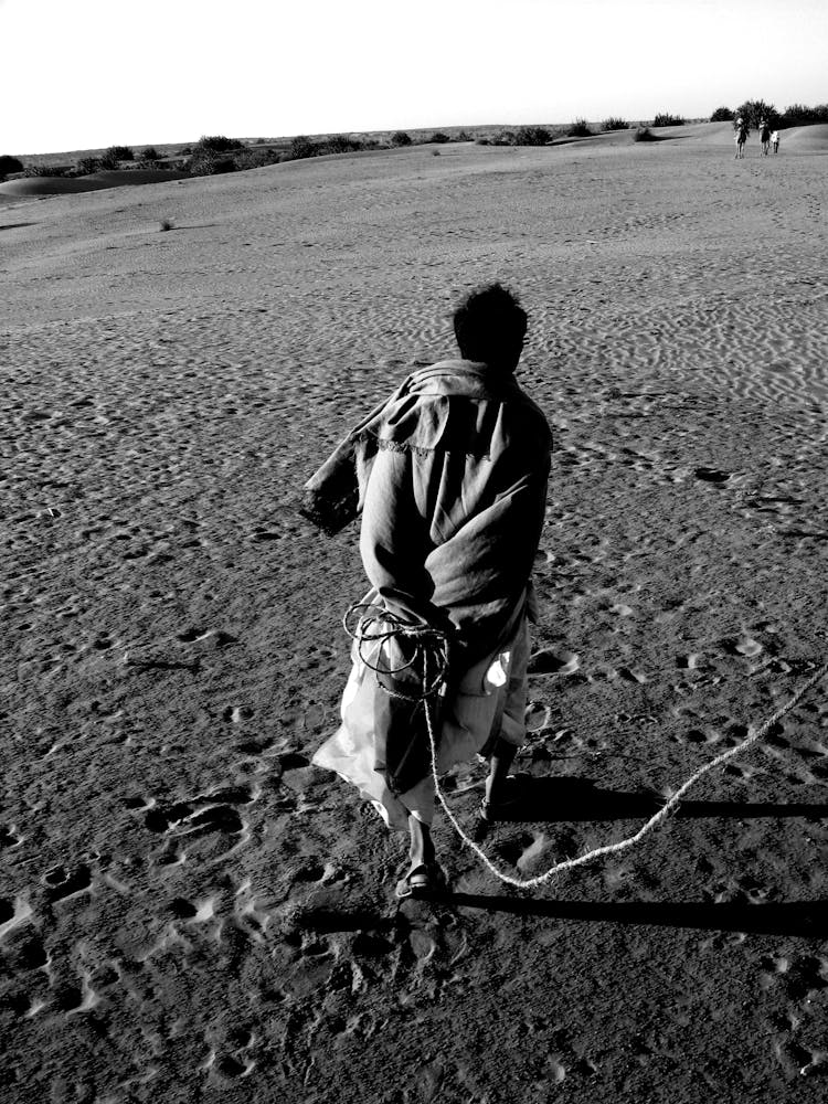 Man Walking With Rope On Desert