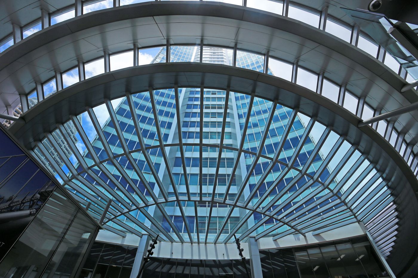 A skyscraper seen through a curved glass roof — photo by Jeffry Surianto on Pexels
