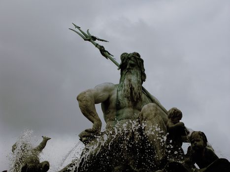 Low-angle shot capturing a dramatic statue of Poseidon with dynamic water splashes.