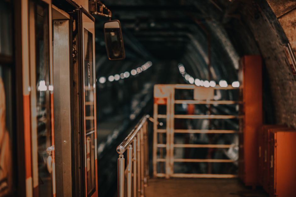 Moody view of a subway train in a dimly lit underground tunnel, evoking a sense of mystery.