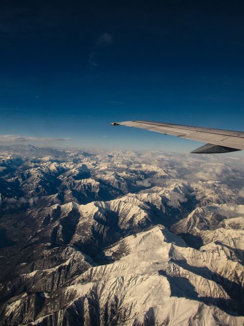 Free A breathtaking view of snow-covered mountains from an airplane window. Stock Photo