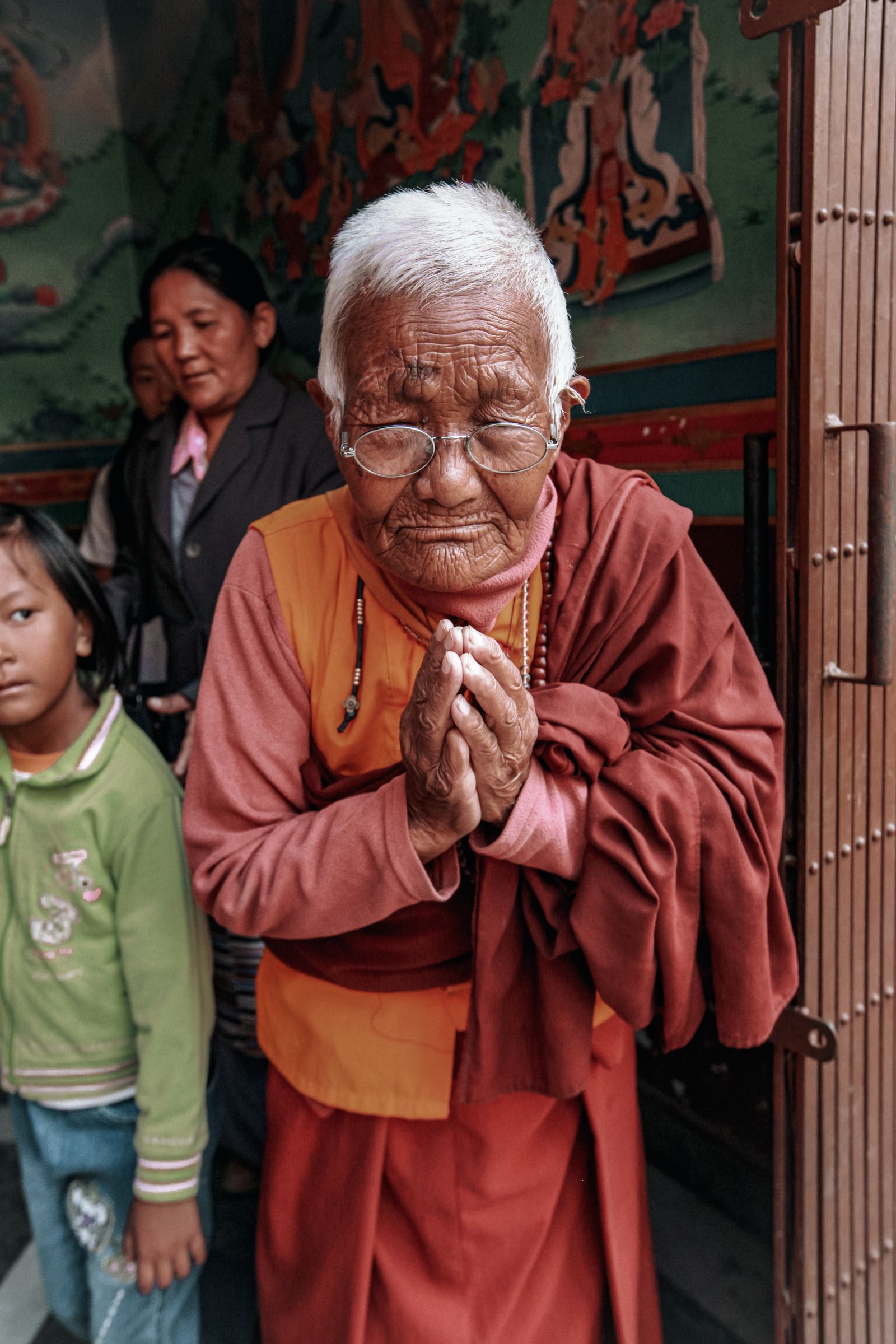 Person's hands folded in prayer inside a temple