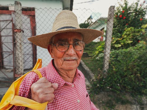 Close-up Photo of an Elderly Man in Woven Sunhat 