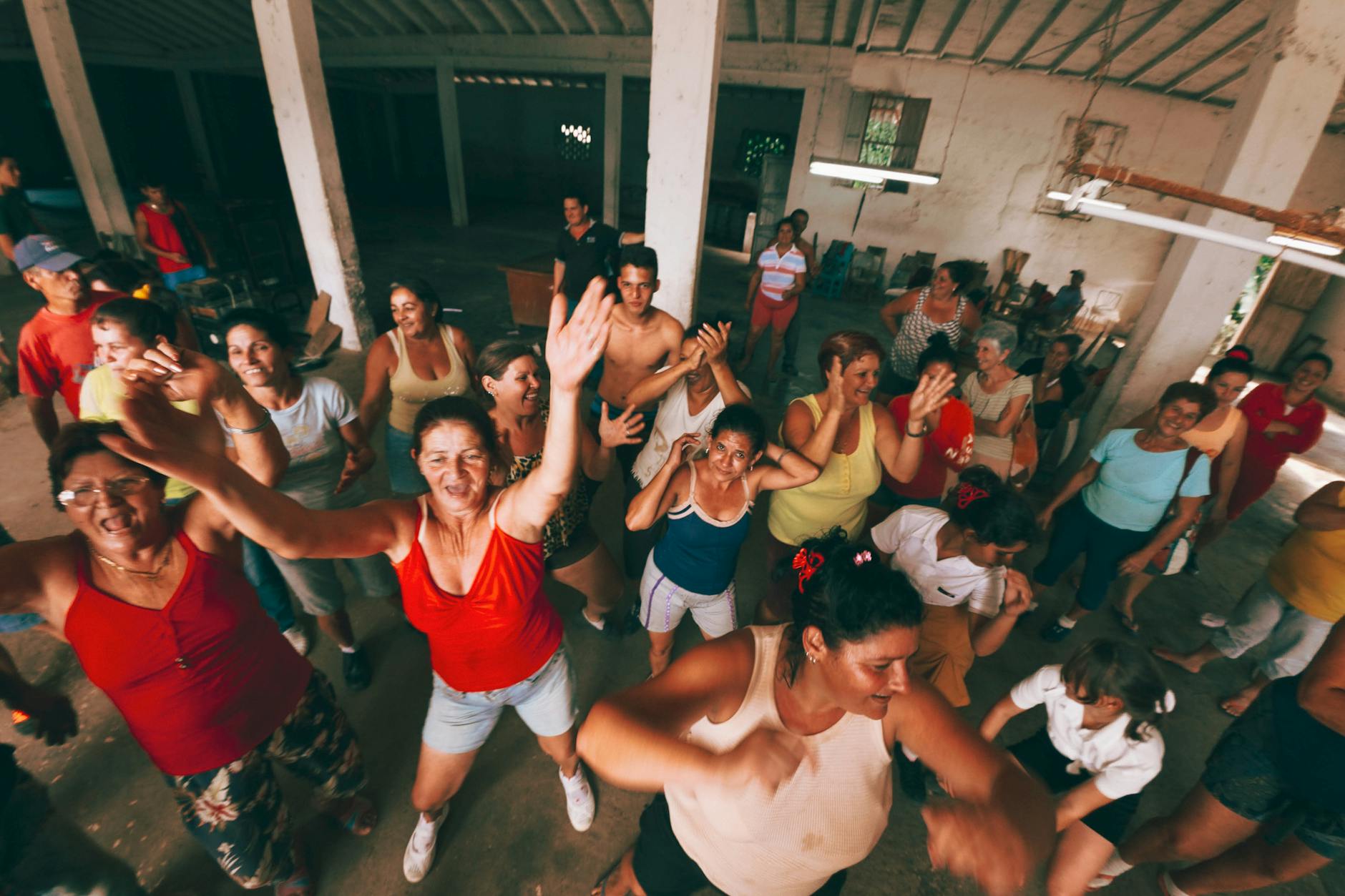 Energetic group of adults dancing indoors, expressing joy and community spirit.