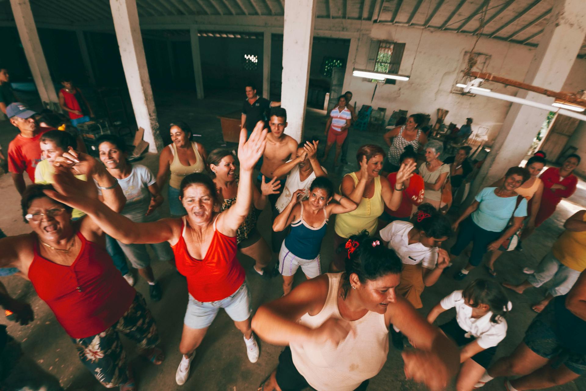 Energetic group of adults dancing indoors, expressing joy and community spirit.