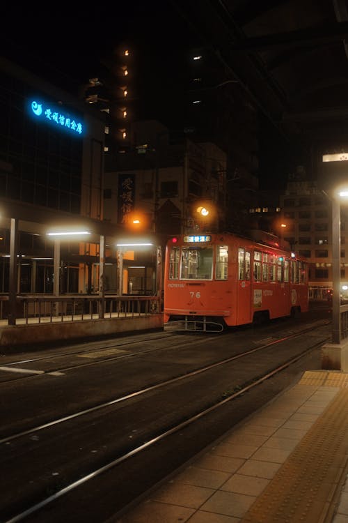 Red Tram on the Street during Night Time