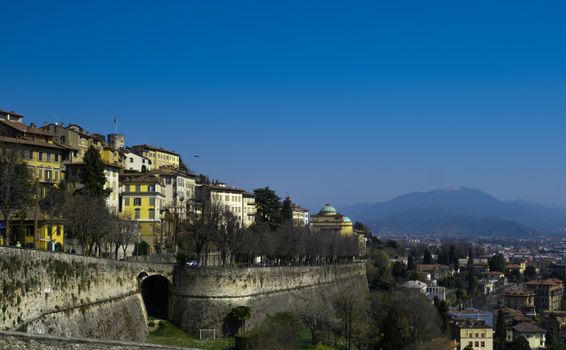 Picturesque view of Bergamo's historic old town with rooftops and a beautiful skyline against clear blue skies.