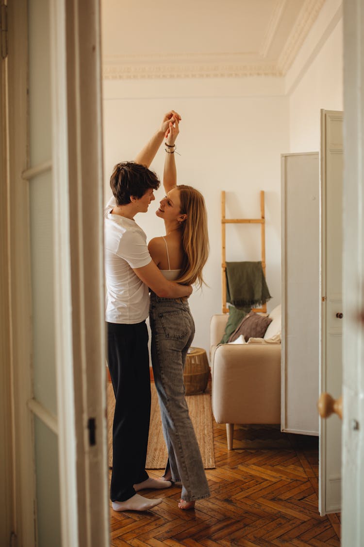 Couple Dancing And Smiling In Living Room